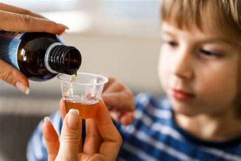 Bambini che prendono uno sciroppo vitaminico
