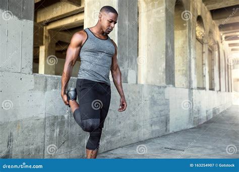 Atleta di bodybuilding che si allunga dopo un allenamento intenso