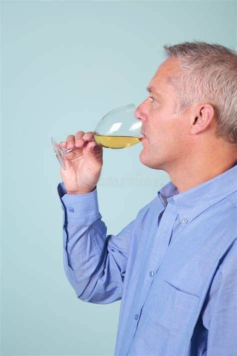 Uomo che beve un bicchiere d'acqua con limone e integratore di magnesio
