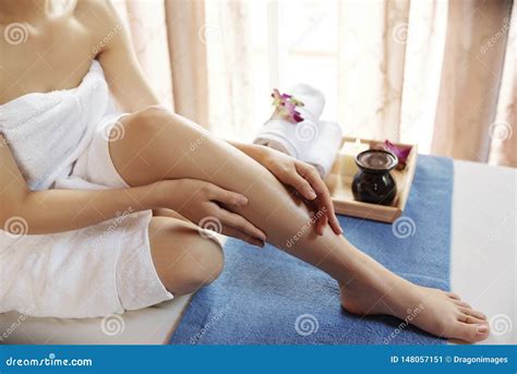 Donna che applica olio sul corpo